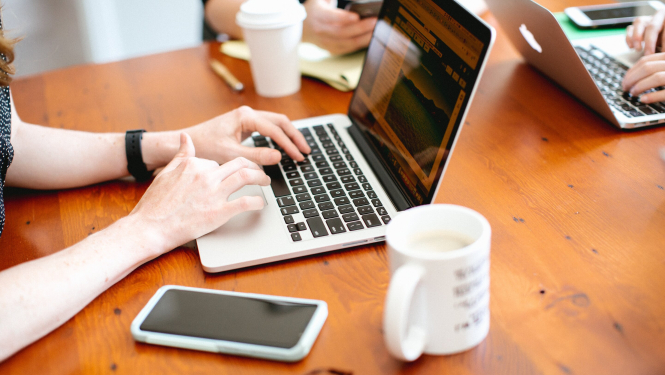 Galds ar datoru, mobilo telefonu un kafijas krūzi