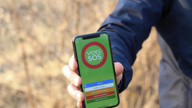 Tālruņa ekrānā attēlota aplkācija VIDES SOS