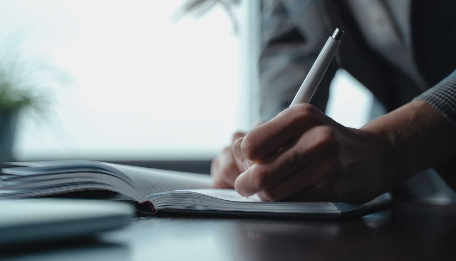 Roka tuvplānā, kas paraksta dokumentu