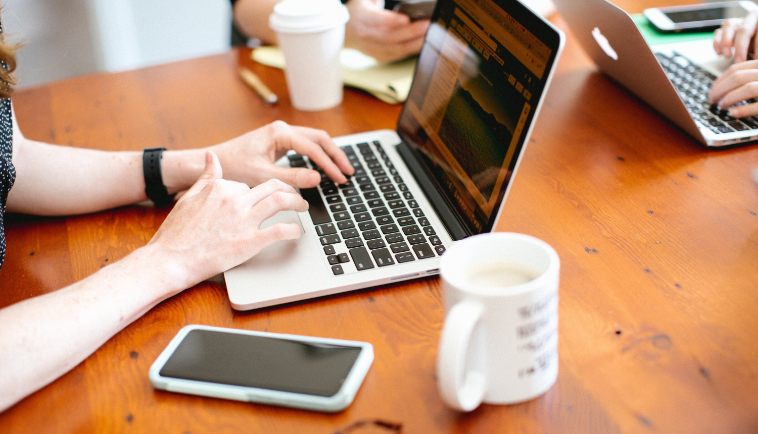 Galds ar datoru, mobilo telefonu un kafijas krūzi